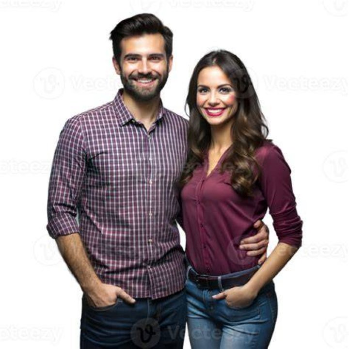 a man and woman standing next to each other on the beach near the ocean