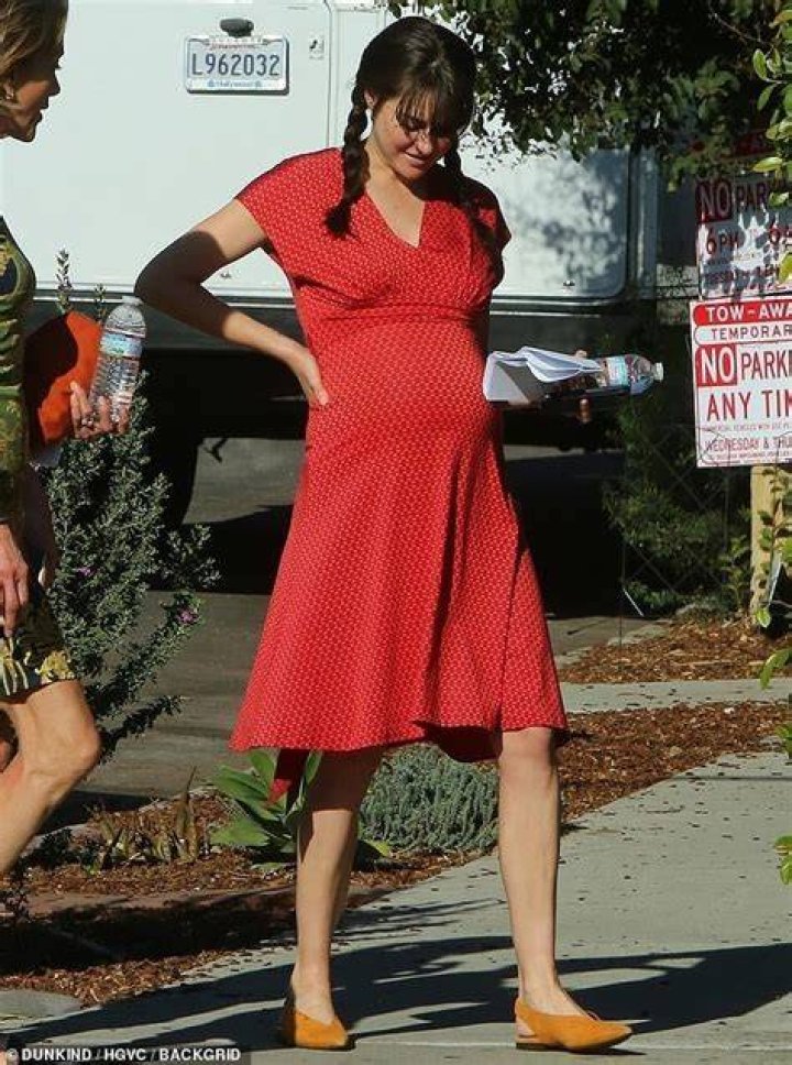 Shailene Woodley wears a prosthetic baby bump beneath her red dress as